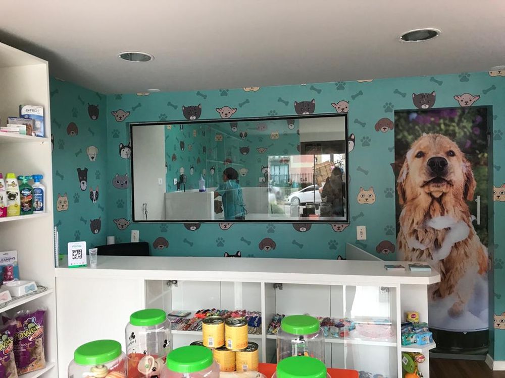 Recepção com balcão branco e janela de vidro para a sala de banho